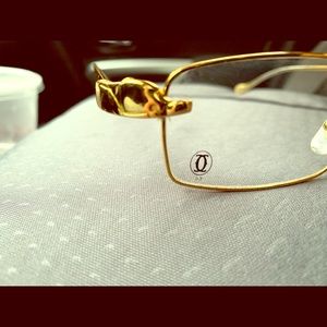 Cartier glasses with golden panther next to lens
